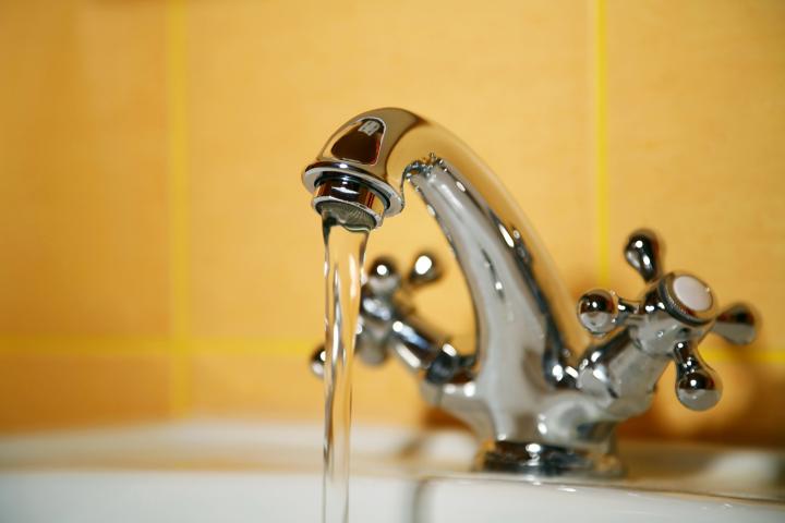 Image of a bathroom tap running water into a basin
