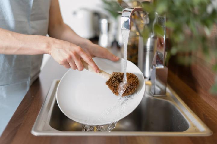 Person using water at kitchen sink Person using water at kitchen sink