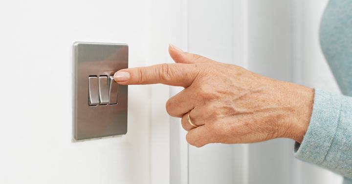 Woman's hand switching a light switch