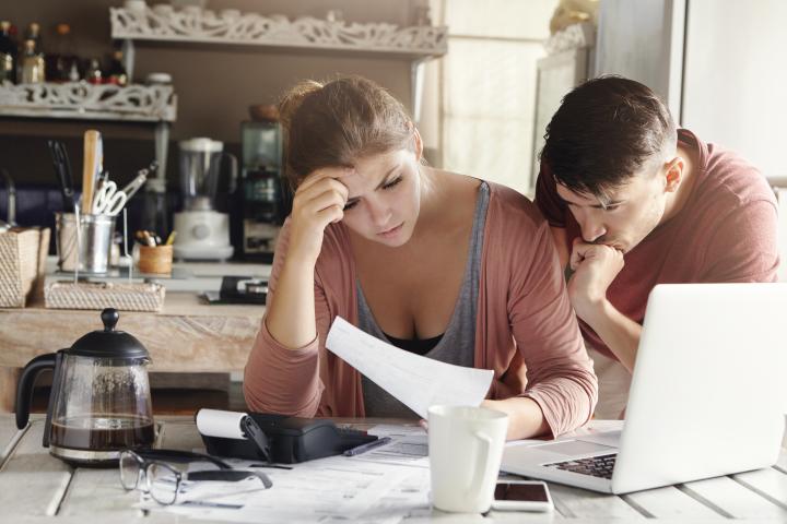 Couple looking stressed at bills