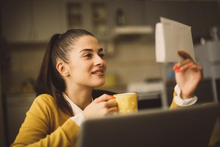 A woman looking at a bill and smiling