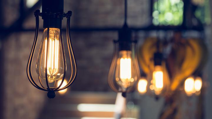 A photo showing decorative lightbulbs hanging in a row from the ceiling.