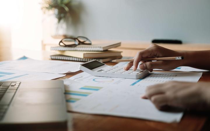 Person using calculator while looking over bills