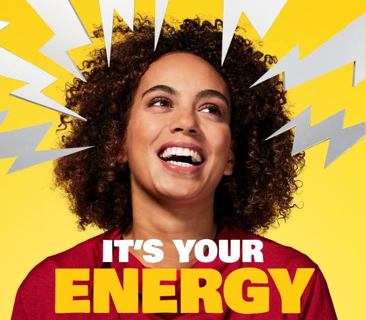 A woman smiling, with cartoon lightning bolts around her head