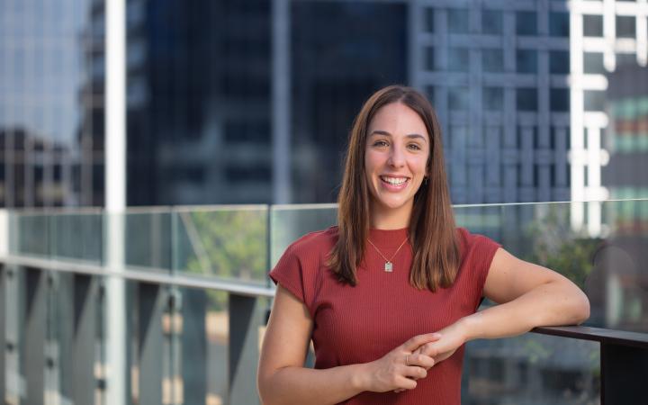 Cristina, an Essential Services Commission employee standing and smiling outside on a patio