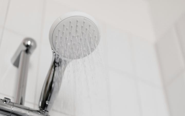 Close up of shower head spraying water