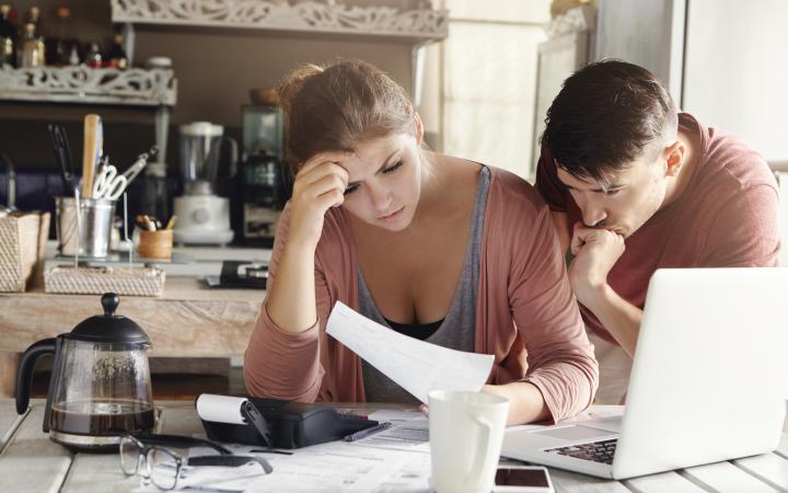 Couple looking stressed at bills