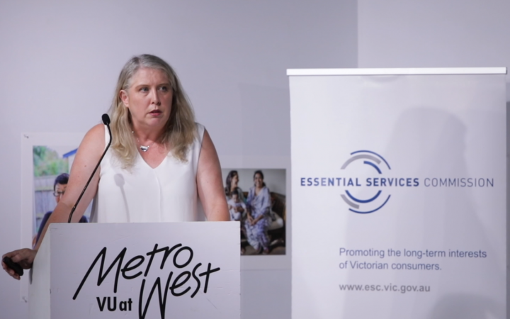 An image of family violence speaker Lisa McAdams giving a lecture on a podium.