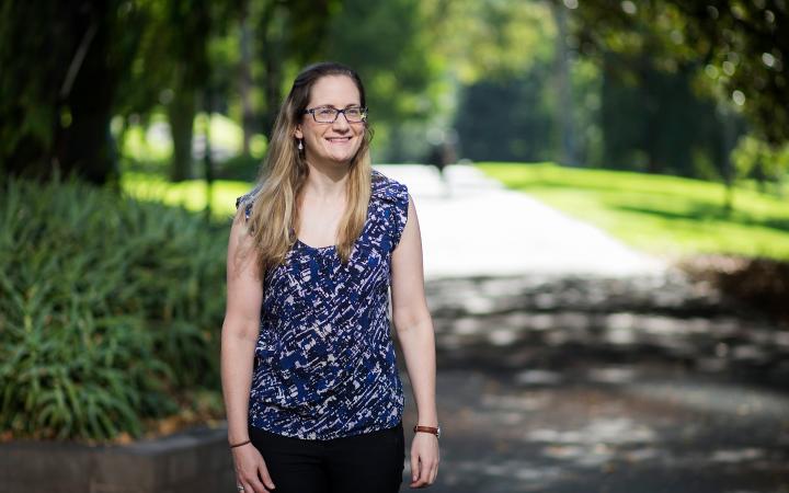 Sarah, an Essential Services Commission employee, in a garden smiling at something that is off-camera.