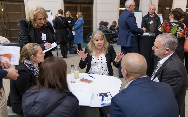 An image of family violence speaker Lisa McAdams (centre) chatting to two women and two men at the commission's family violence forum on 30 August 2018.